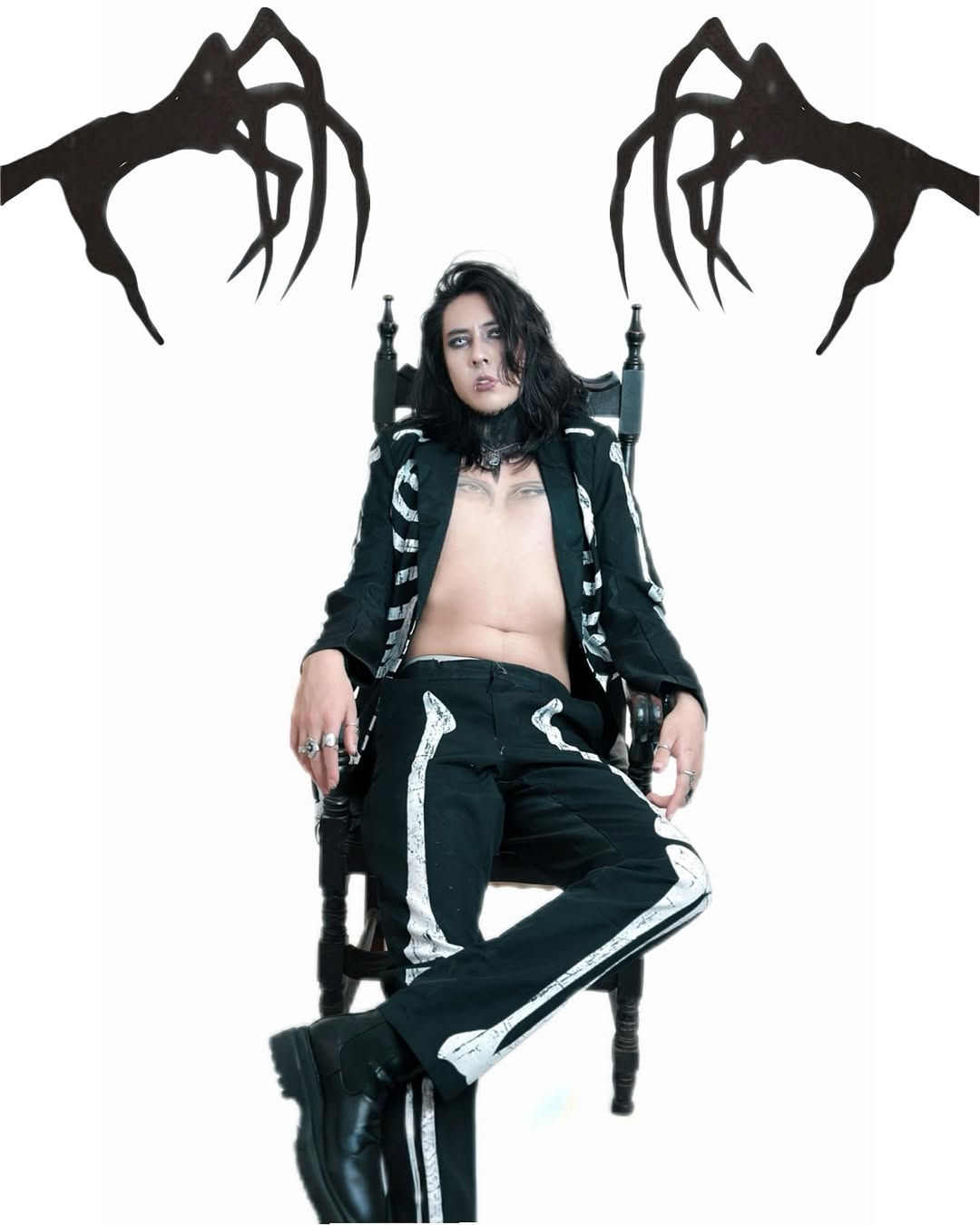 Johan Peraza seated in an open skeleton outfit flanked by shadow monster hands illustration