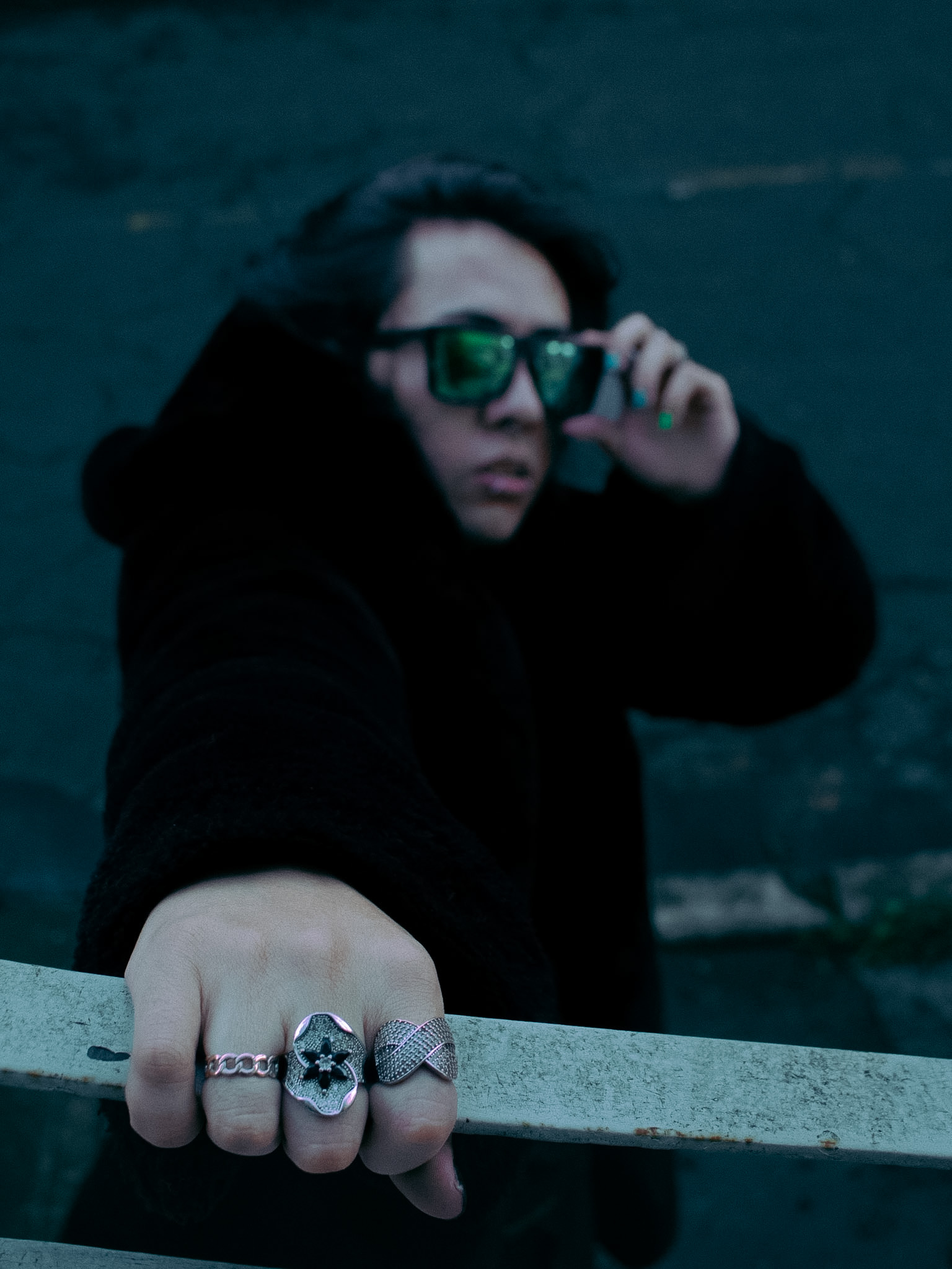 Johan Peraza, medium shot wearing a dark fur coat and sunglasses looking past the camera