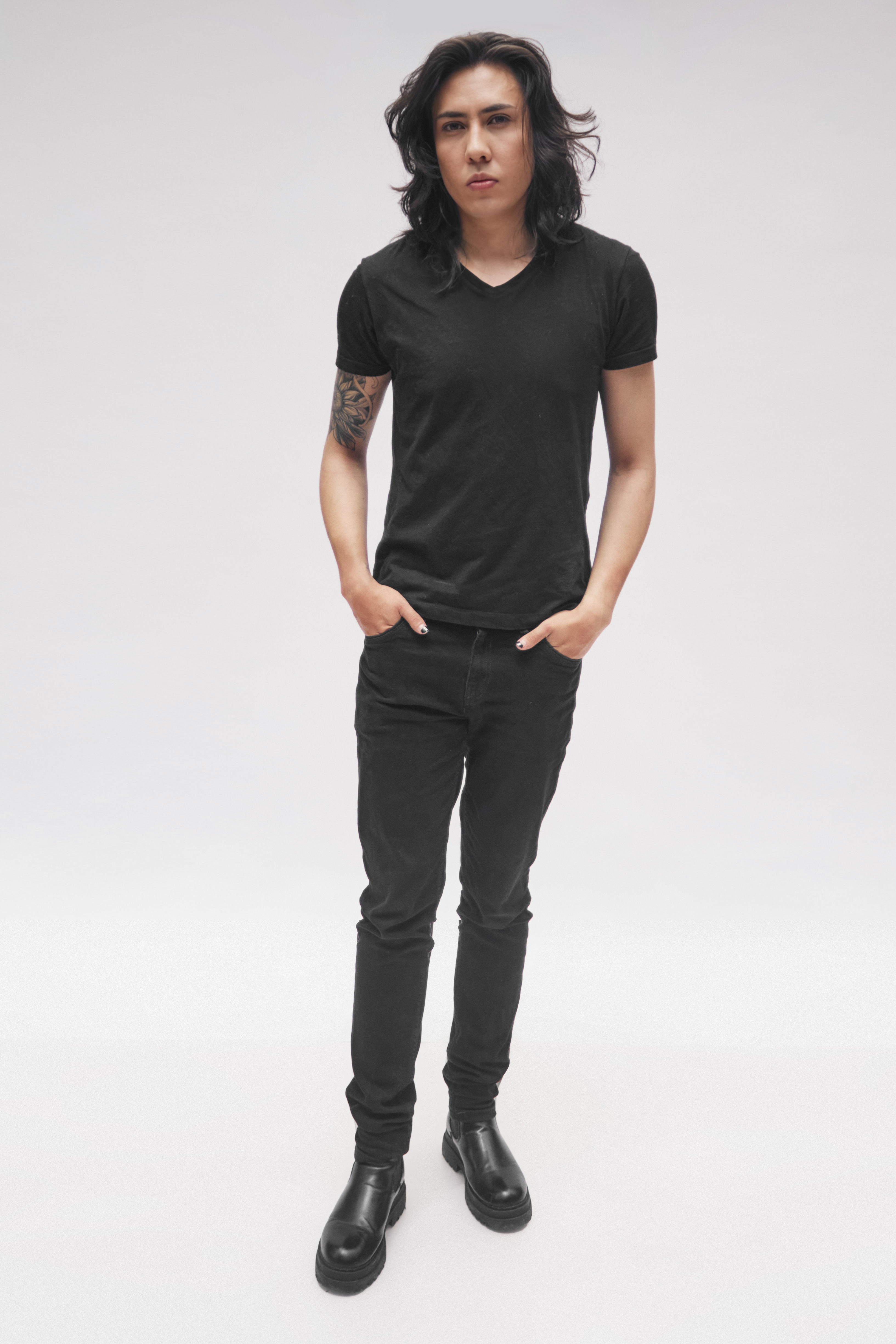 Johan Peraza, full-length casting digital photo in all-black attire against a white studio wall