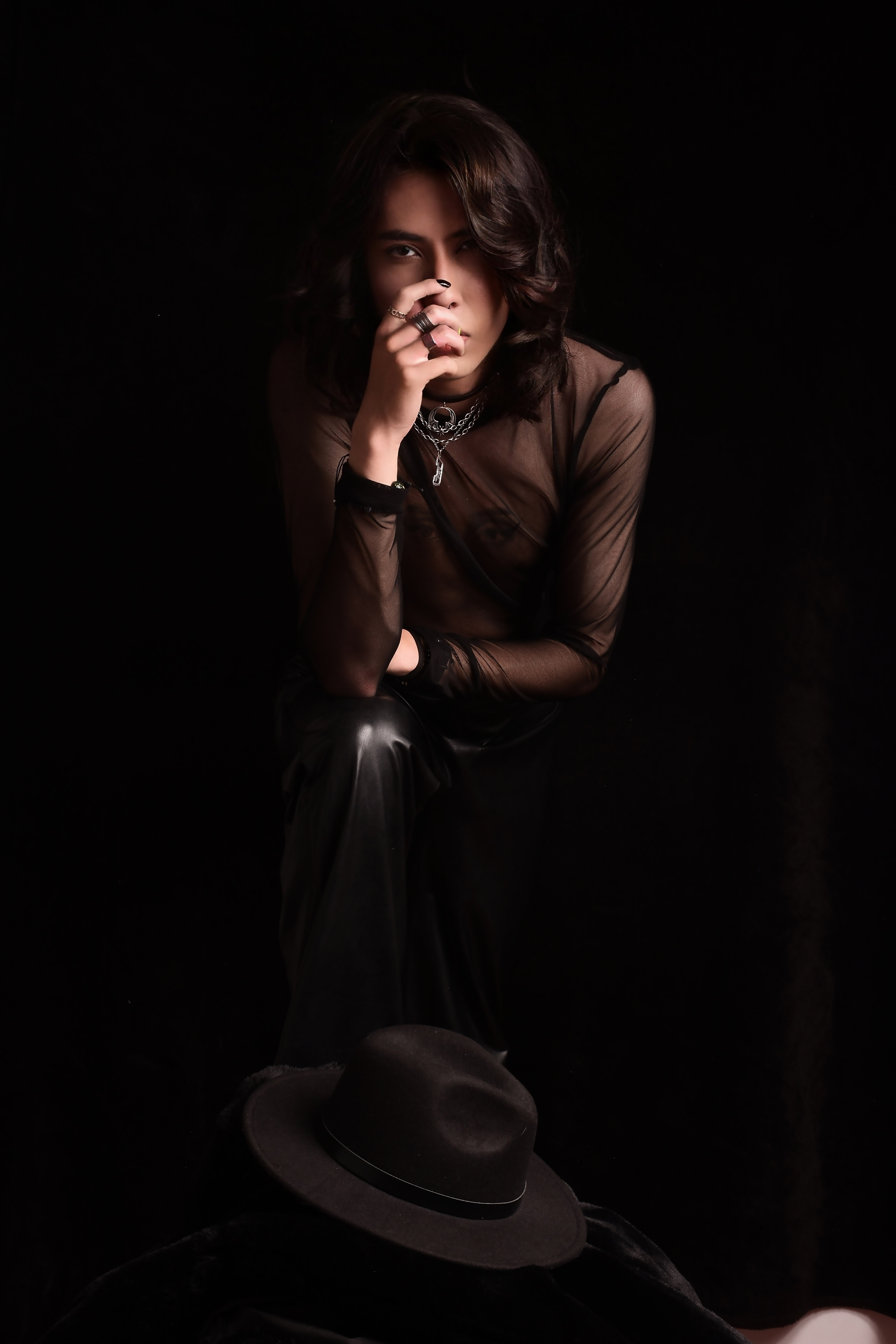 Johan Peraza, dark moody live performance portrait singing into a microphone on stage