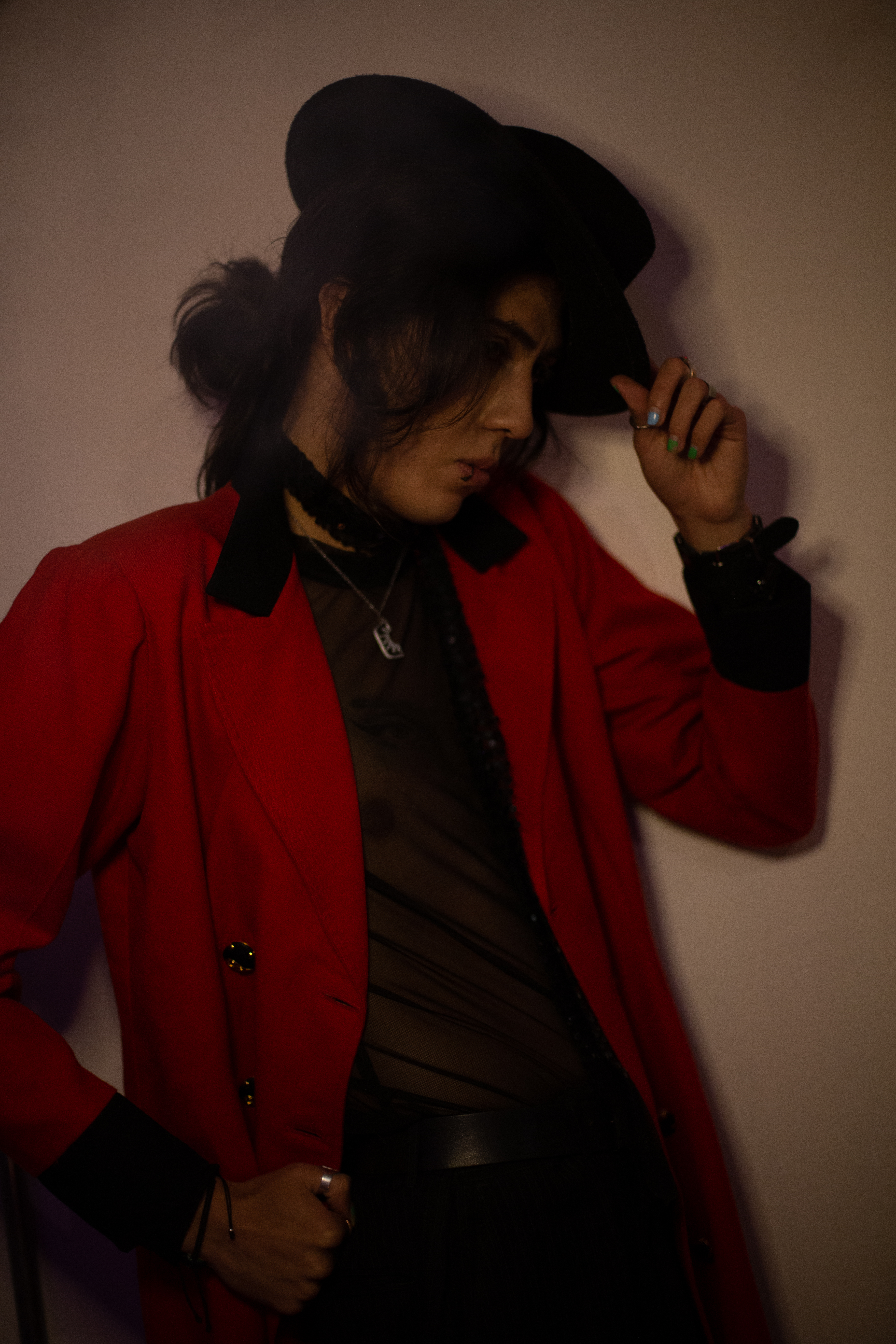ohan Peraza, studio portrait in a striking red blazer and black wide-brimmed hat